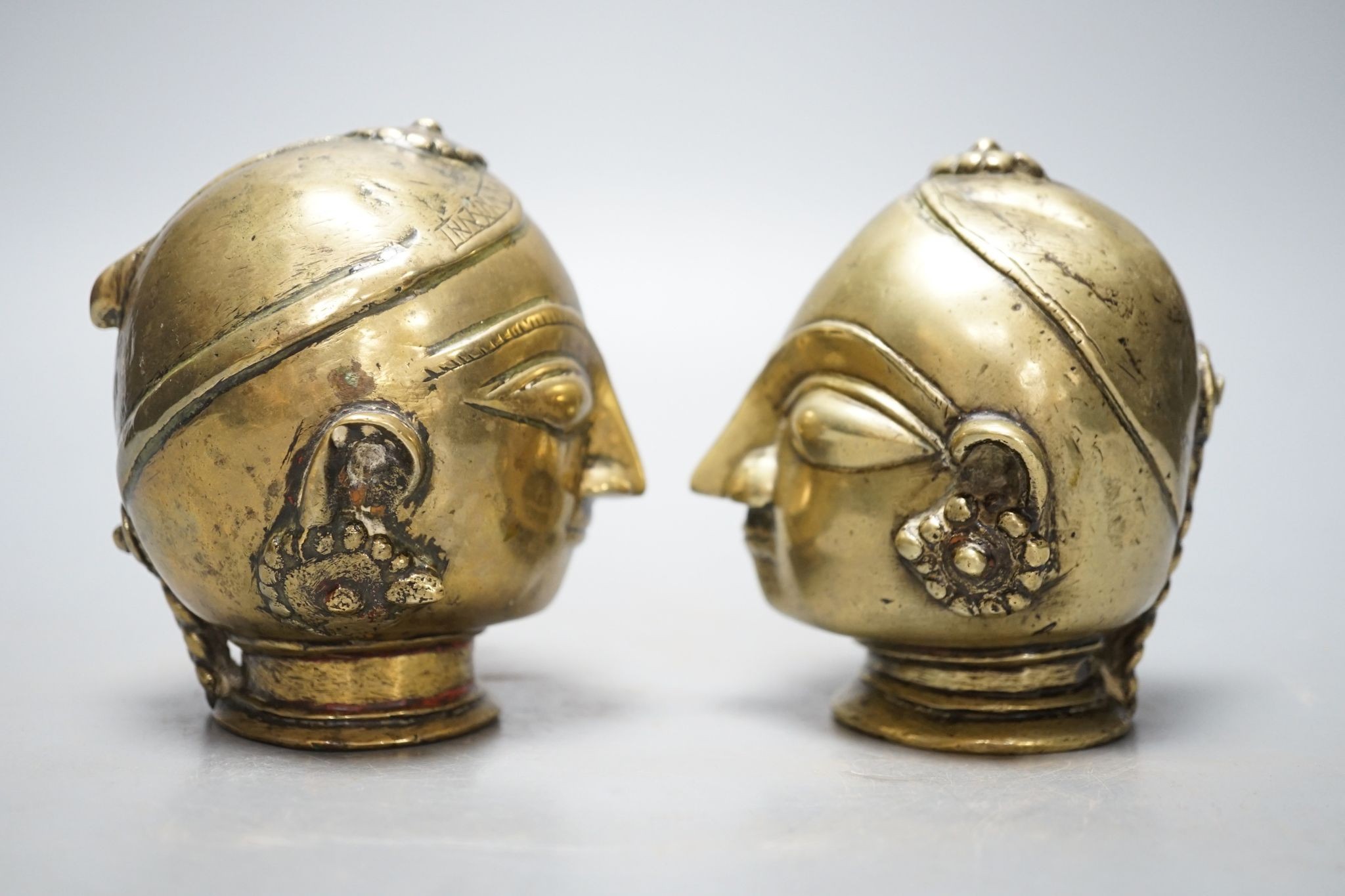 A pair of Indian bronze heads 11cm